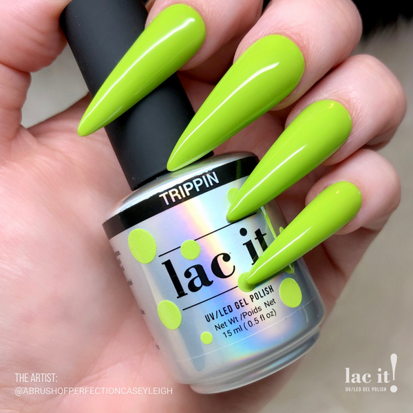 en Vogue Lac It! Trippin vibrant chartreuse-green crème UV/LED gel nail polish for professional nails and extensions on long stiletto shaped manicured nails holiding polish bottle